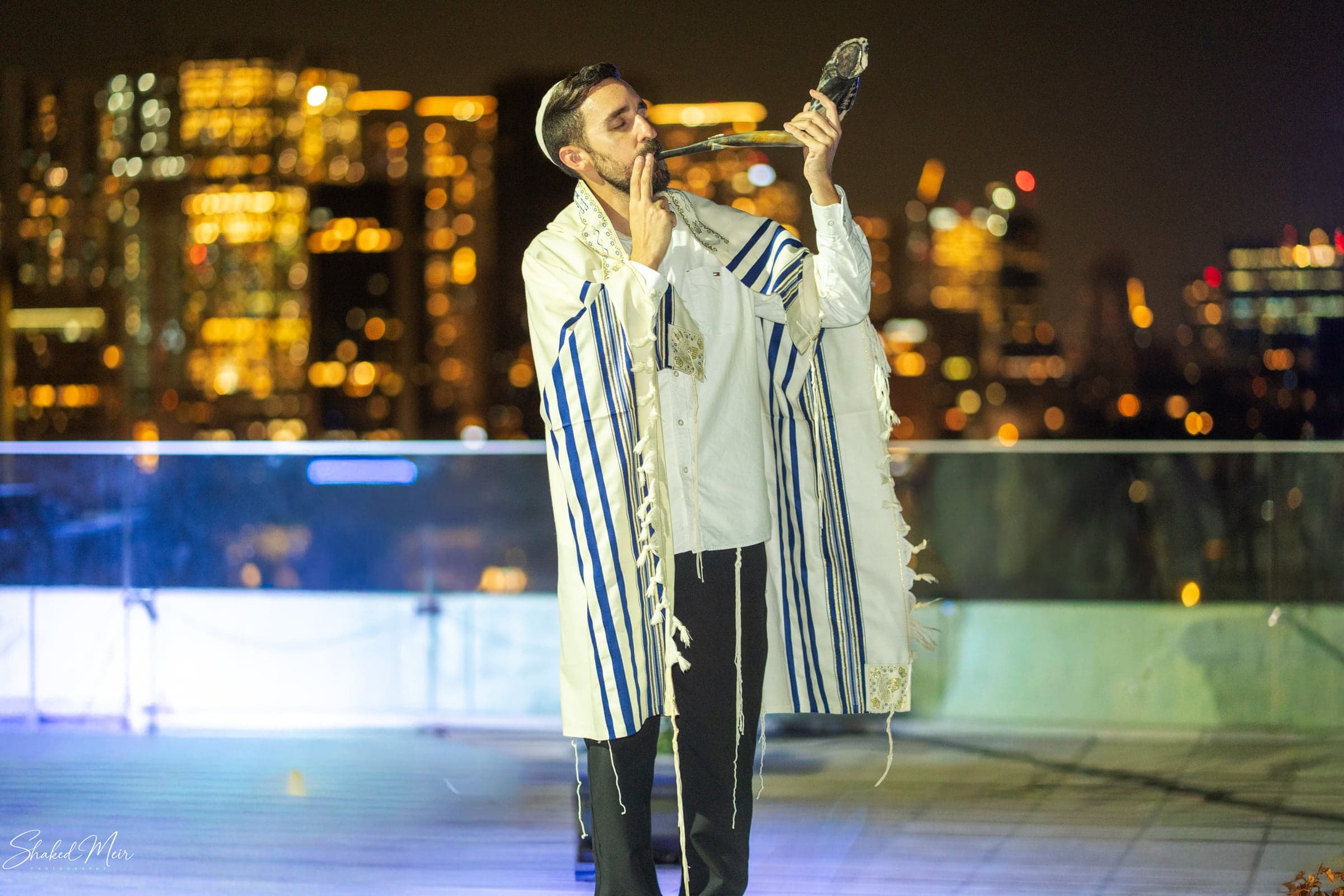 רגע שירה באירוע על רקע אורות בניינים בלילה